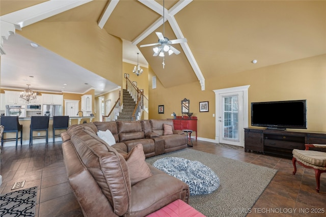 living area with high vaulted ceiling, ceiling fan with notable chandelier, stairway, crown molding, and baseboards