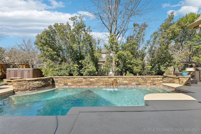 outdoor pool with a fenced backyard and a hot tub