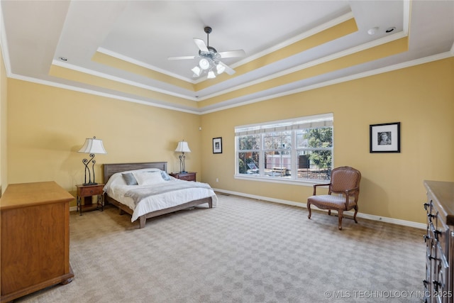 bedroom featuring ceiling fan, baseboards, carpet, a tray ceiling, and ornamental molding