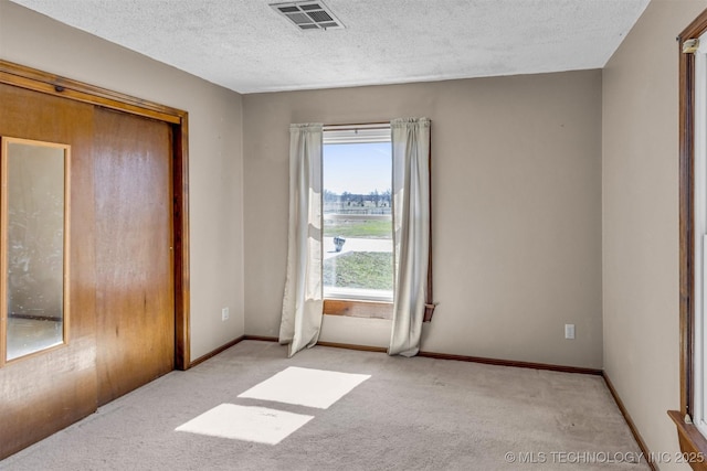 bedroom with baseboards, carpet, visible vents, and a textured ceiling