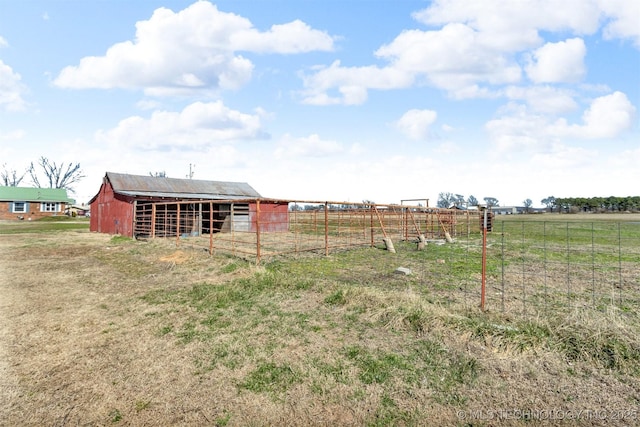 view of yard with an outbuilding, a rural view, and an exterior structure