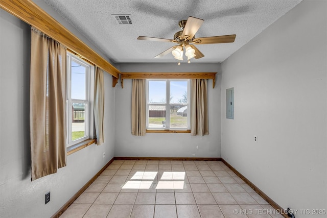 unfurnished room featuring light tile patterned floors, visible vents, plenty of natural light, and a ceiling fan