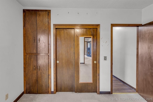 unfurnished bedroom with baseboards, carpet, and a textured ceiling