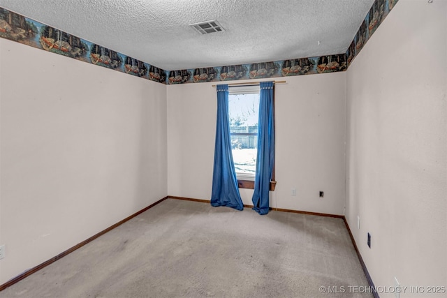 carpeted empty room featuring visible vents, a textured ceiling, and baseboards