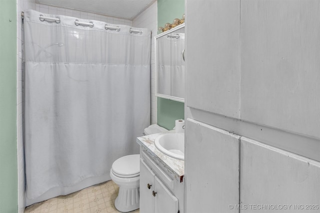 full bathroom featuring tile patterned floors, toilet, a shower with shower curtain, and vanity