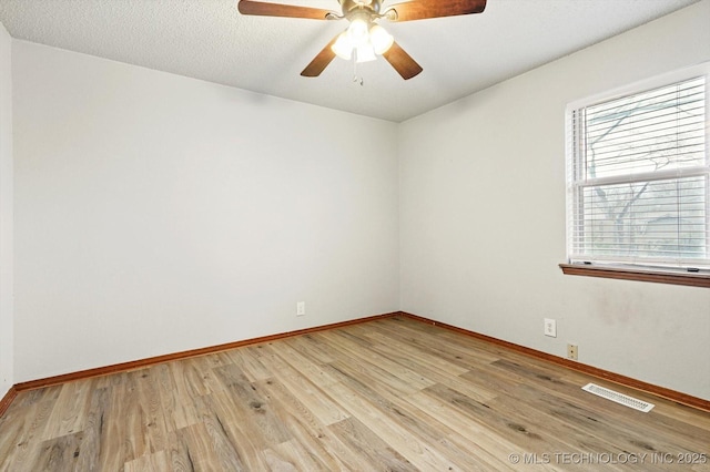 unfurnished room with light wood-type flooring, visible vents, a ceiling fan, a textured ceiling, and baseboards