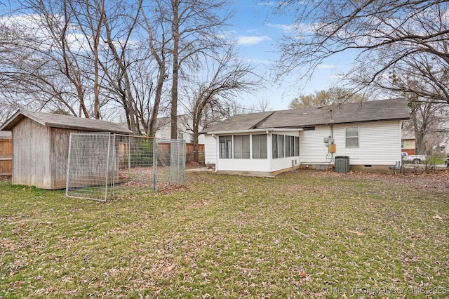 back of property with an outbuilding, a yard, fence, and crawl space