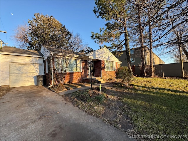 single story home featuring brick siding, concrete driveway, and a front yard