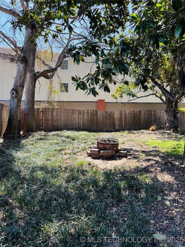 view of yard featuring a fire pit and fence