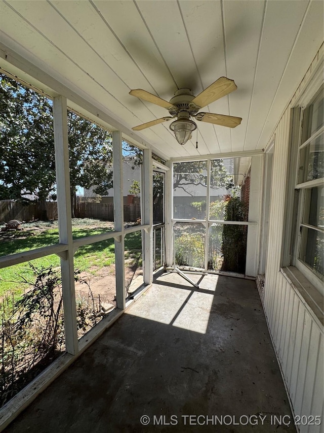 unfurnished sunroom featuring a wealth of natural light and ceiling fan