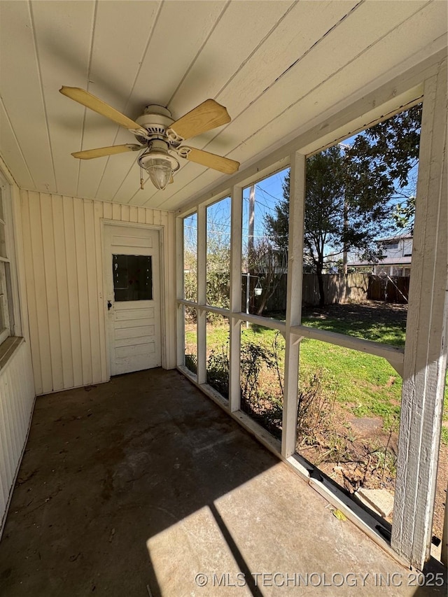 unfurnished sunroom featuring ceiling fan