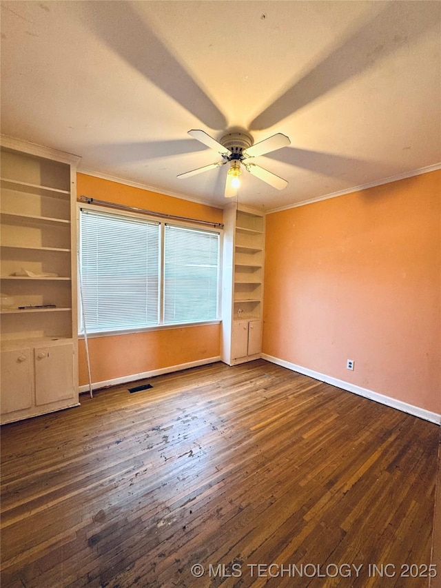 unfurnished room featuring crown molding, hardwood / wood-style flooring, baseboards, ceiling fan, and built in features
