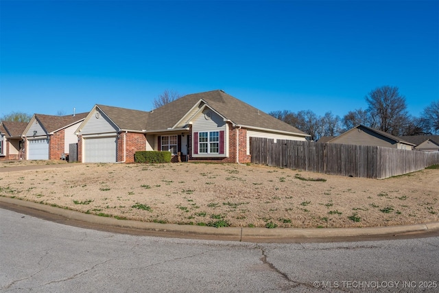 view of front facade featuring a garage, brick siding, driveway, and fence