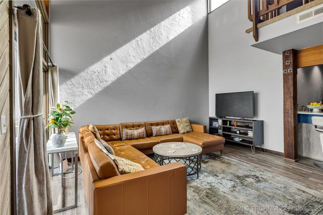 living room with wood finished floors, visible vents, and baseboards