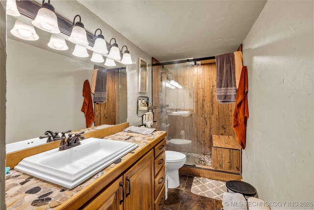 full bathroom with a shower stall, toilet, and vanity