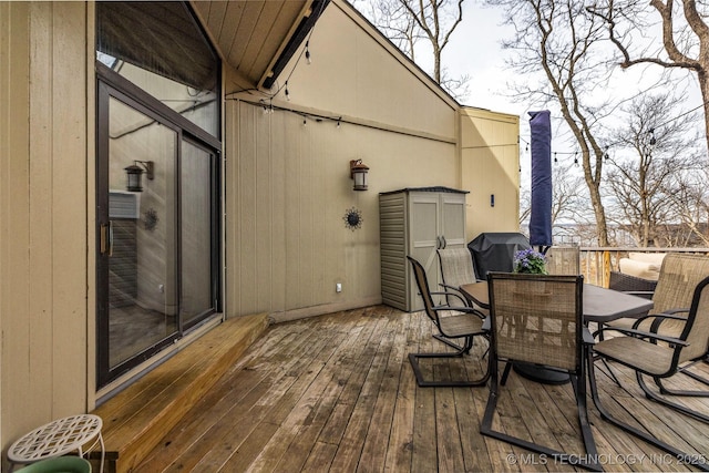 wooden deck featuring grilling area and outdoor dining space