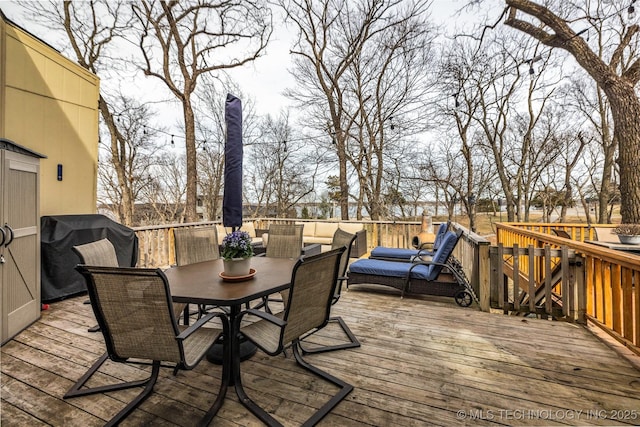 deck with outdoor dining space and area for grilling