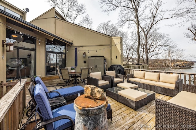 deck with outdoor dining area, a water view, area for grilling, and outdoor lounge area