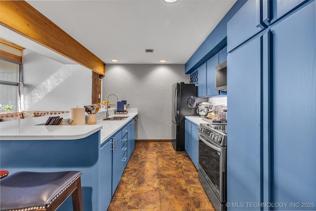 kitchen featuring a peninsula, electric range, light countertops, blue cabinets, and high quality fridge