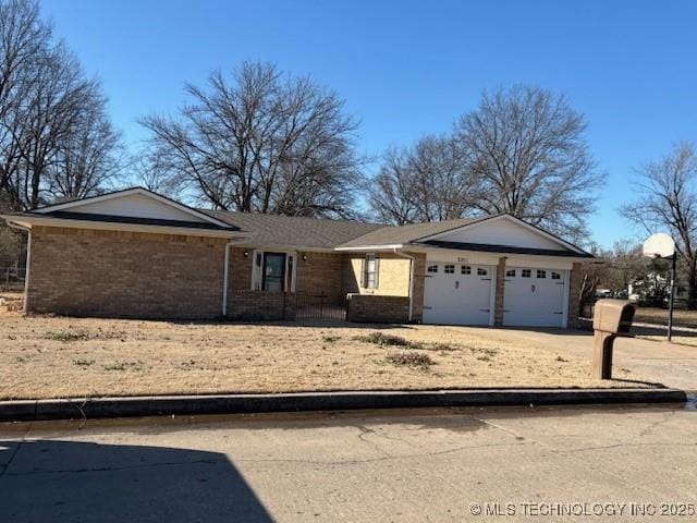 ranch-style home with a garage, brick siding, and driveway