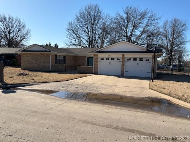 ranch-style home with concrete driveway and a garage