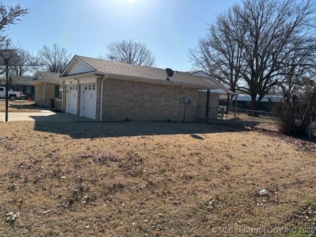 exterior space with brick siding, fence, and a garage