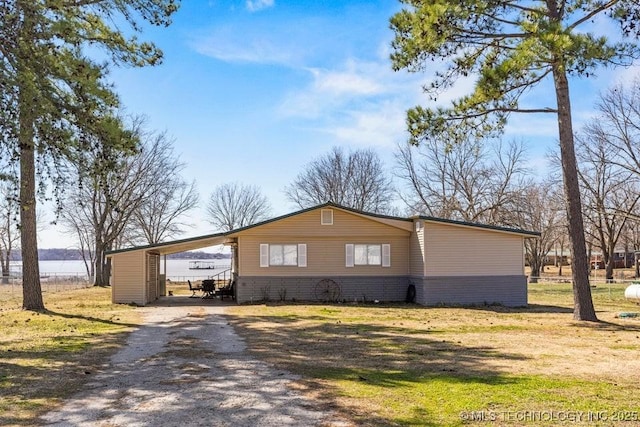 view of side of home with brick siding, a carport, and driveway