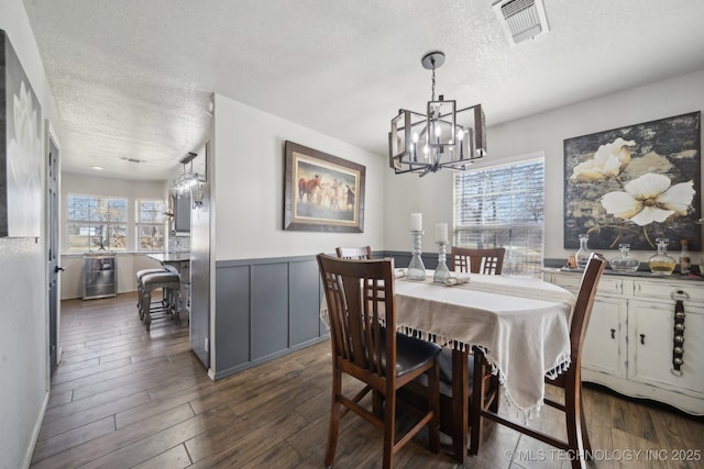 dining space with visible vents, a textured ceiling, and dark wood-style floors