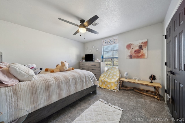 carpeted bedroom with visible vents, a textured ceiling, and a ceiling fan