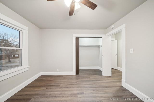 unfurnished bedroom featuring a closet, a ceiling fan, baseboards, and wood finished floors