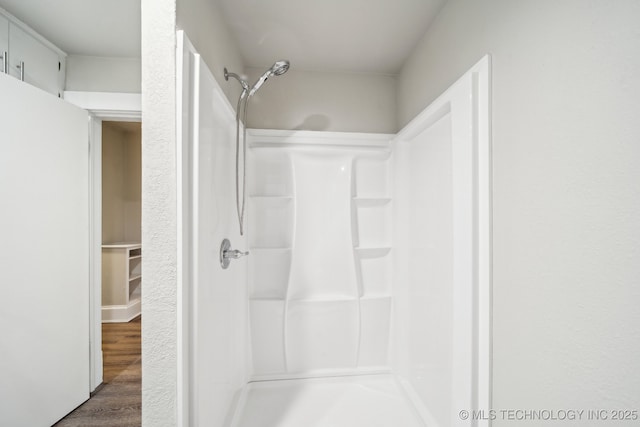 full bath featuring wood finished floors and walk in shower