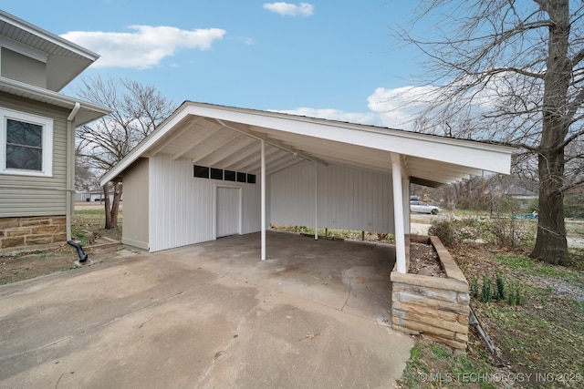 view of parking / parking lot with an attached carport and concrete driveway