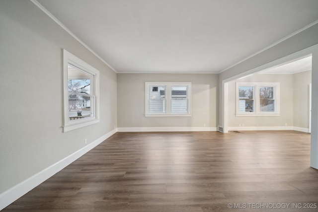 unfurnished living room with a healthy amount of sunlight, dark wood-style flooring, and crown molding