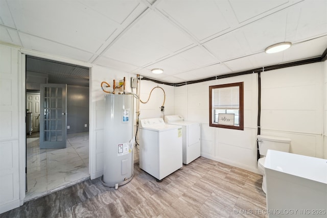 laundry room featuring laundry area, electric water heater, and separate washer and dryer