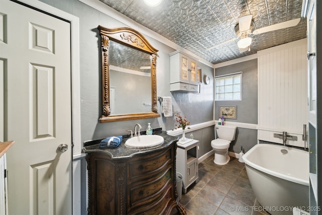 full bathroom featuring vanity, a soaking tub, toilet, and an ornate ceiling