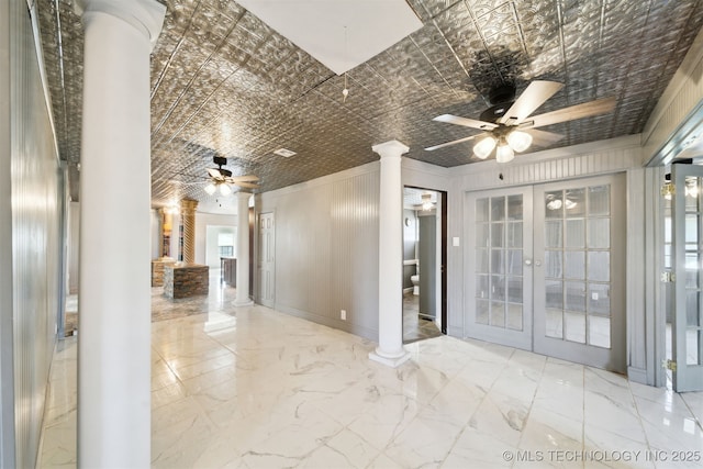 empty room featuring french doors, an ornate ceiling, marble finish floor, and ornate columns