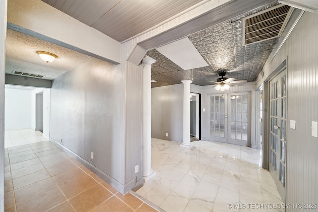 hall with marble finish floor, french doors, visible vents, and ornate columns