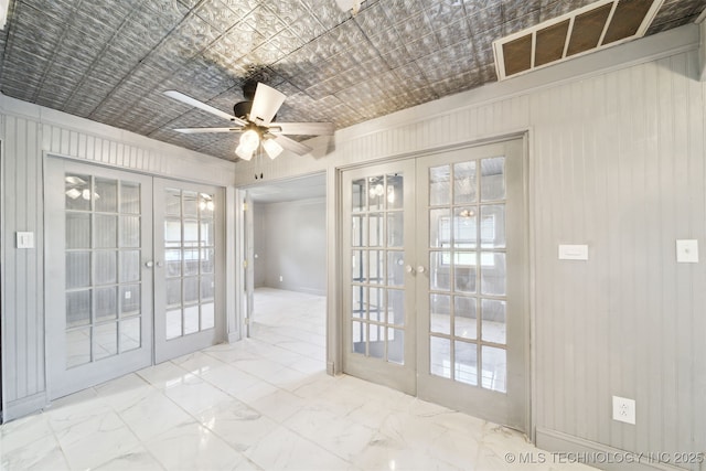 empty room with visible vents, french doors, marble finish floor, an ornate ceiling, and a ceiling fan