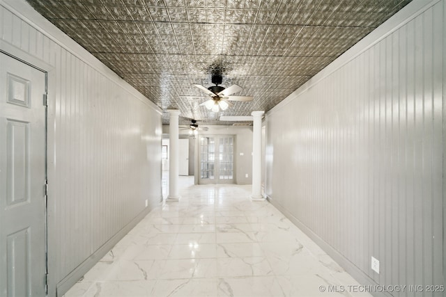 hall featuring baseboards, an ornate ceiling, marble finish floor, and ornate columns