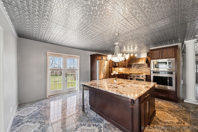 kitchen featuring light stone counters, decorative columns, an ornate ceiling, and appliances with stainless steel finishes