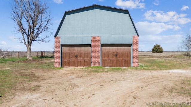 detached garage featuring fence