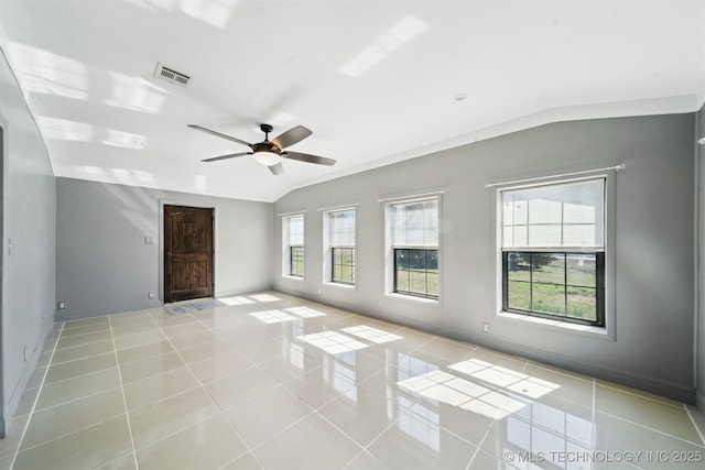 unfurnished room with light tile patterned floors, visible vents, baseboards, and vaulted ceiling