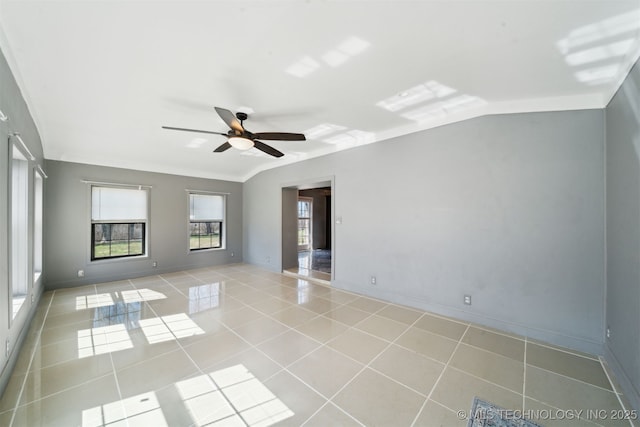 tiled empty room with baseboards, a ceiling fan, and vaulted ceiling