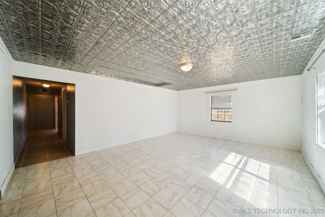 unfurnished room featuring visible vents, an ornate ceiling, baseboards, and crown molding