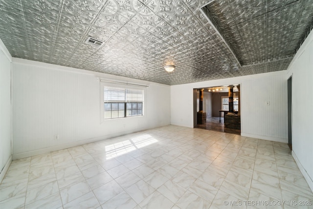 unfurnished room with visible vents and an ornate ceiling