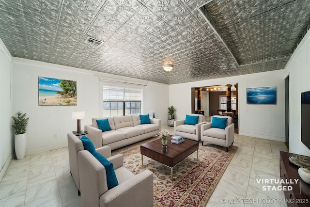 living room with visible vents, marble finish floor, an ornate ceiling, and baseboards