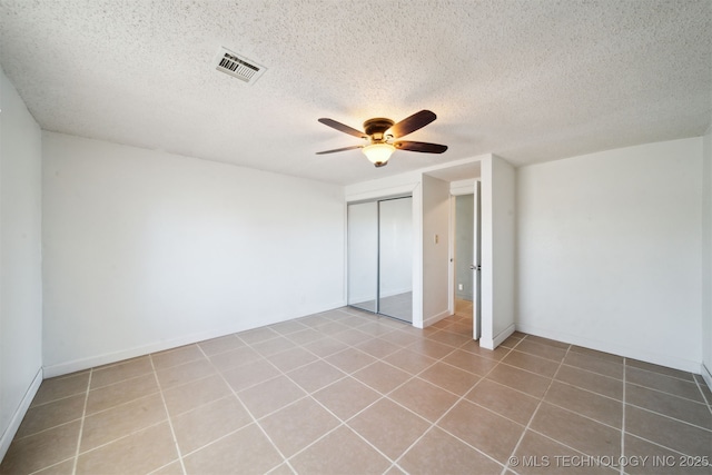 unfurnished bedroom featuring visible vents, a textured ceiling, a closet, and ceiling fan