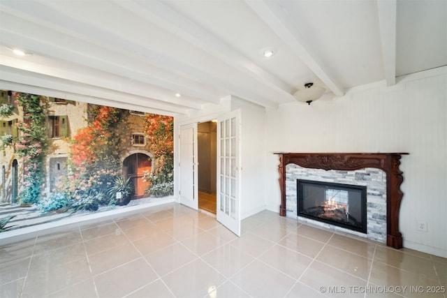 unfurnished living room with beamed ceiling, baseboards, a glass covered fireplace, and tile patterned flooring