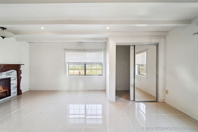 unfurnished bedroom featuring beam ceiling, tile patterned floors, and a fireplace