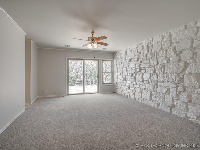 carpeted empty room featuring visible vents, baseboards, a ceiling fan, and ornamental molding